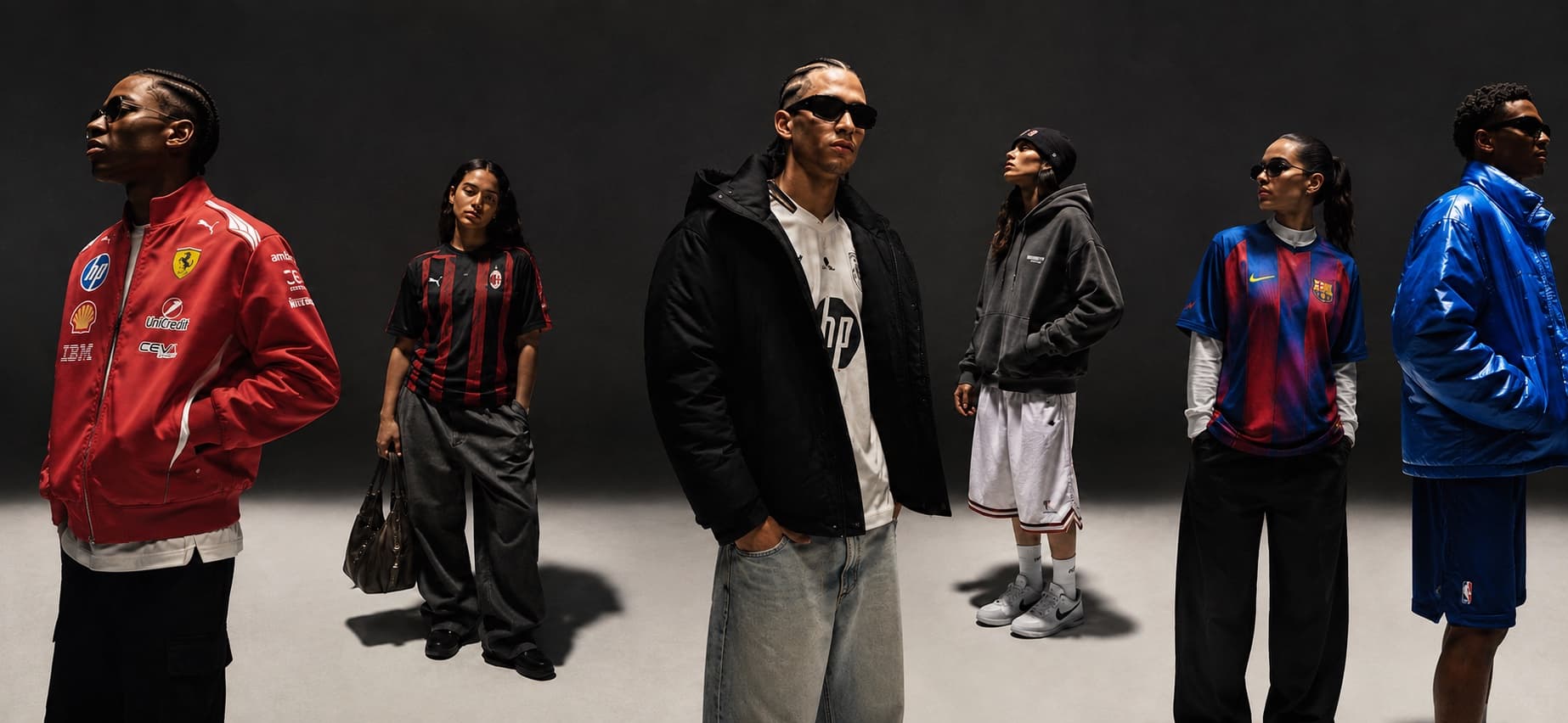 Sei figure in maglie da stadio e capi sartoriali, in piedi in uno studio scuro.
